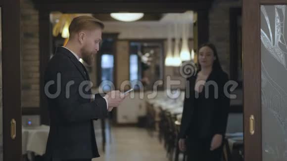 男女商业伙伴在餐厅见面人们握手穿着优雅西装的女士来到视频的预览图