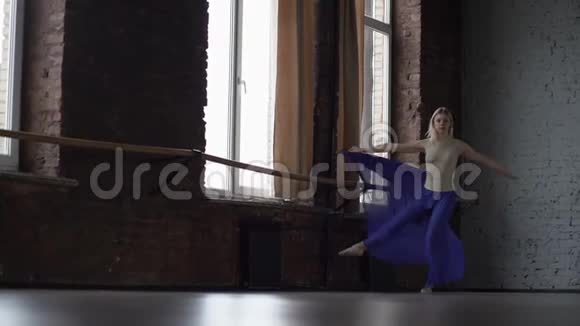 年轻的金发舞者以缓慢的动作旋转视频的预览图