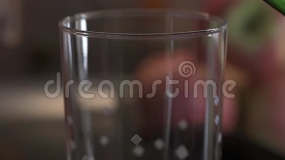 绿色雌龙饮料倒入水玻璃与许多气泡视频的预览图