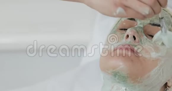 美容师的漂亮女孩做水疗洗面膜剥皮美容和身体皮肤护理视频的预览图