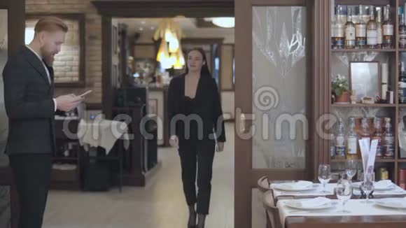 男女商业伙伴在餐厅见面人们握手穿着优雅西装的女士来到视频的预览图