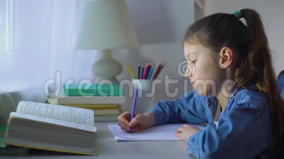 伤心的女学生在桌子上做作业视频的预览图