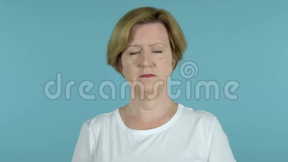 悲伤的老女人被隔离在蓝色的背景上视频的预览图