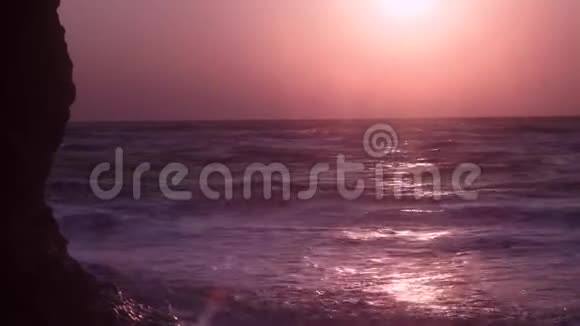 大浪泡沫流动在粘土山上在橙色黎明的背景下视频的预览图