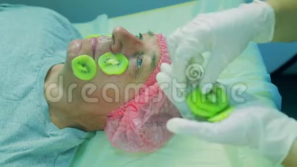 化妆师的女人的手从男人的人身上摘下一个面具从小腿猕猴桃视频的预览图
