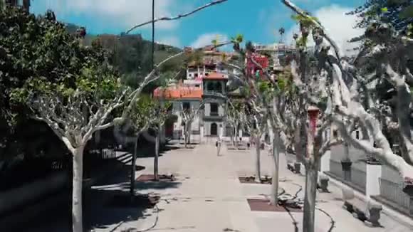 空中观景无人驾驶飞机飞越位于山区的一个五颜六色的西班牙小城市古老多彩的房子视频的预览图