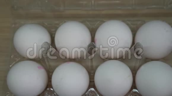 盒子里放着一盒白鸡蛋盘子里画着五颜六色的复活节彩蛋视频的预览图
