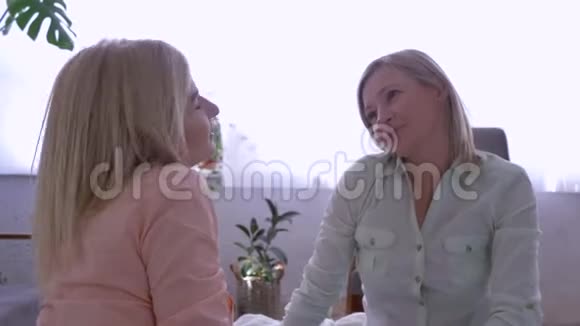母爱关怀微笑的母亲与成年女儿拥抱在家聊天视频的预览图