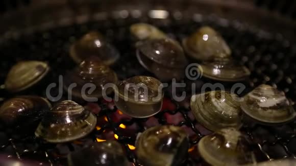 在一家中国餐馆亚洲烧烤店在煤气烤架上打开蛤蜊视频的预览图
