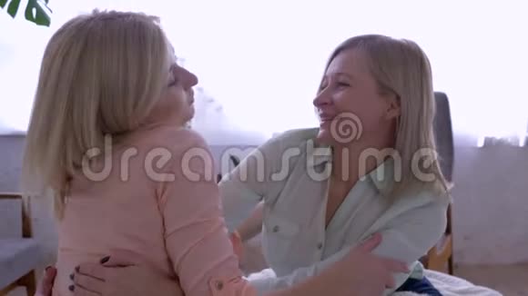 母女关系开心的妈妈在家里和大女儿拥抱交流视频的预览图