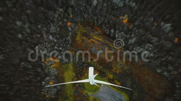 无人机向后移动倾斜揭示风车涡轮在冬季森林工作可再生能源的未来概念视频的预览图