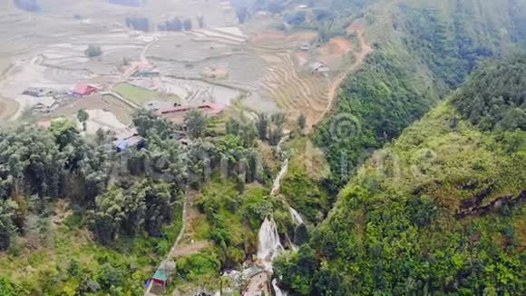 鸟瞰绿色梯田稻田和在萨帕猫村的山谷建筑4K移动飞行无人机视频的预览图