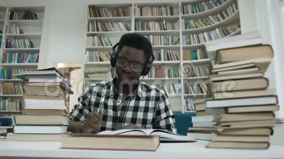 非洲男学生在图书馆完成写作讲座后头痛扔笔视频的预览图