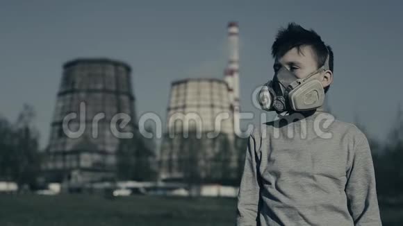戴防毒面具的小男孩对着工业烟斗拍特写环境污染概念视频的预览图
