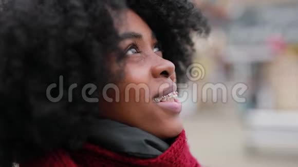 非洲女人惊奇地看着城市的天空视频的预览图