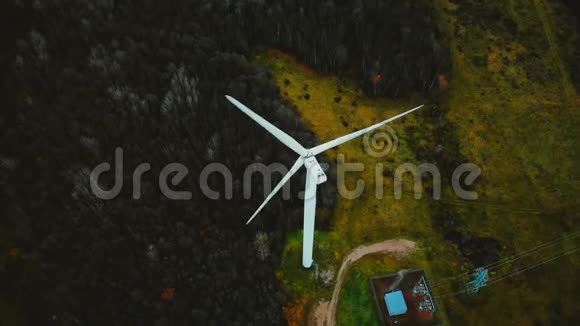 在郁郁葱葱的绿色森林中可替代的可持续能源美丽的高空俯视工作风车涡轮机视频的预览图