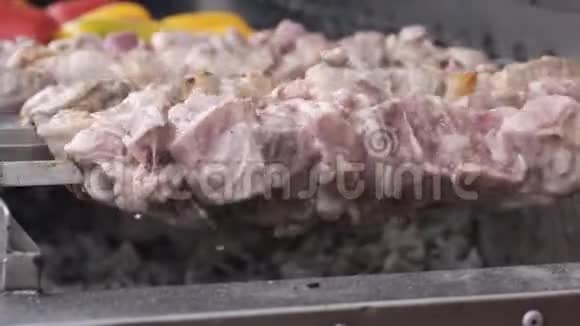 烤串上的大块猪肉在烤架上旋转视频的预览图