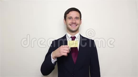 年轻英俊的商人展示他的黄金信用卡微笑和显示拇指视频的预览图