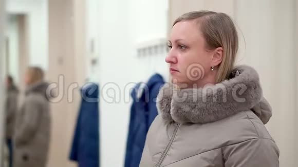 一家服装店里的女人在更衣室里对着镜子看着自己视频的预览图