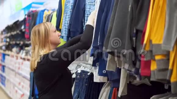 一个在服装店的女人为她的儿子挑选衬衫视频的预览图