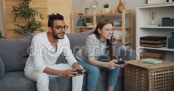 男人和女人幸福的夫妻在公寓里玩电子游戏玩得开心视频的预览图