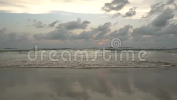 海滩上的日落太阳消失在云层后面视频的预览图
