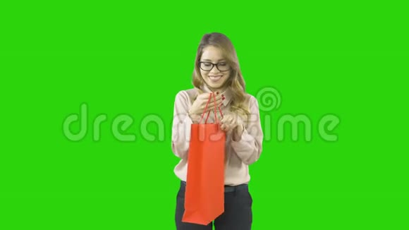 一个穿着严格制服的女孩打开包裹拿出一个打开真诚的盒子检查她的新年礼物视频的预览图