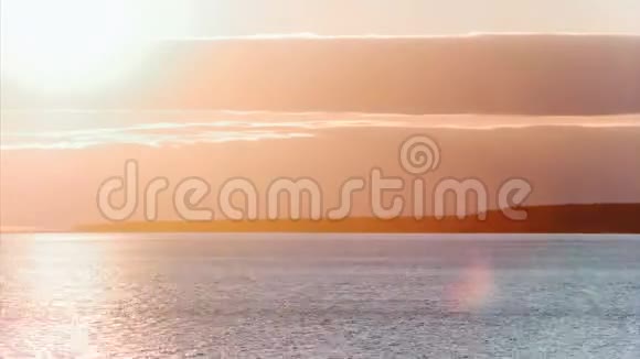 随着时间的推移太阳落在云层后面海上或大湖上的红色粉红色日落视频的预览图
