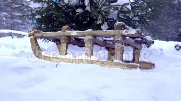 木制的旧雪橇站在云杉下的白雪上视频的预览图