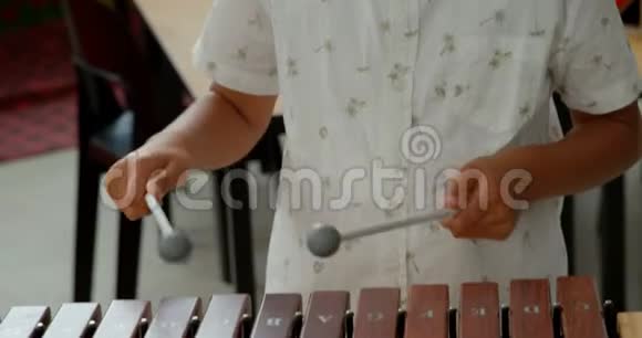 亚洲小学生在学校4k教室玩木琴的正面景色视频的预览图