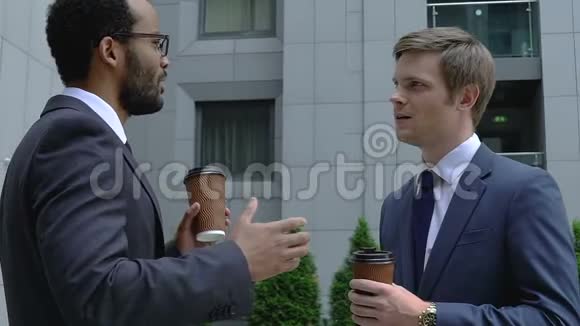 成功的男性律师在休息时间拿着咖啡在外面聊天视频的预览图