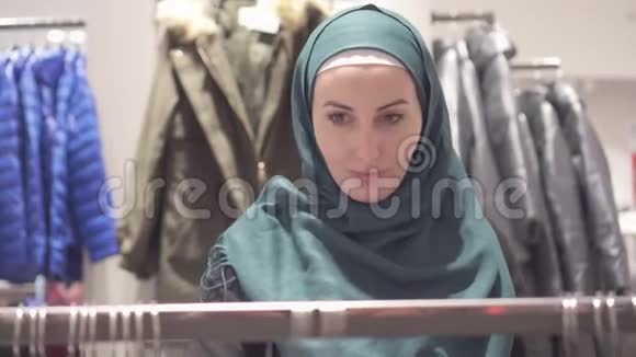 穿着头巾背着背包在店里购物的漂亮穆斯林女人关门了视频的预览图
