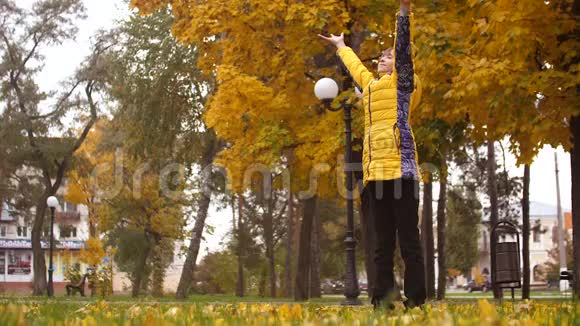 女孩举起双手在秋天的公园里冥想视频的预览图