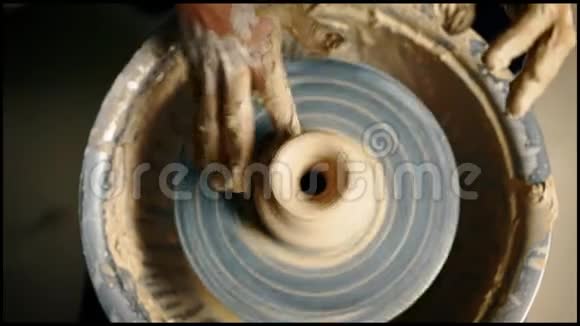 陶工手在陶轮上工作并制作陶罐的俯视图视频的预览图