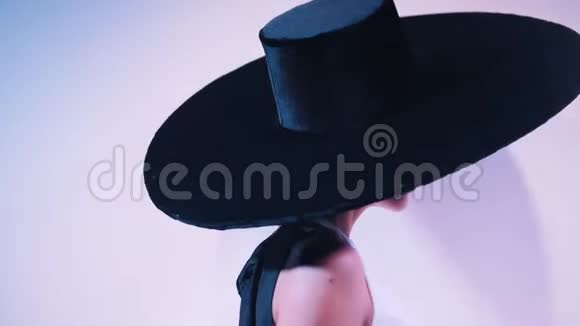 一个戴着黑色优雅大礼帽的女人走到麦克风前开始唱歌视频的预览图