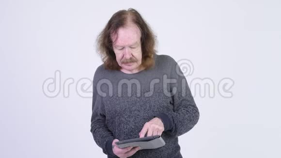 一位留着胡子的快乐老人用数码平板电脑看样子很惊讶视频的预览图