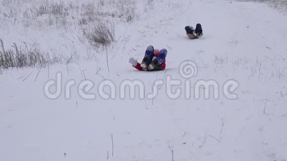 快乐的孩子们乘雪橇从高山上滑过冬天女孩在公园里玩圣诞节视频的预览图