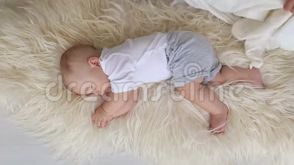 一位有爱心的母亲用蓬松的毯子盖住她刚出生的熟睡的孩子视频的预览图