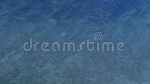 蓝色透明的海水带着石底和小波纹视频的预览图
