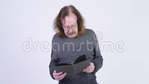 戴着眼镜看书扔书的老人视频的预览图
