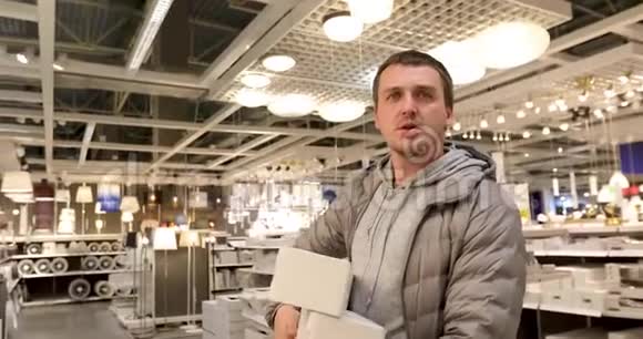 单身男子在家中商店里拿着灯泡视频的预览图