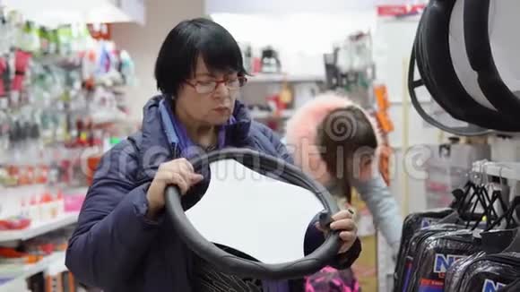 成熟的女人在选择一个软装饰的方向盘的汽车视频的预览图