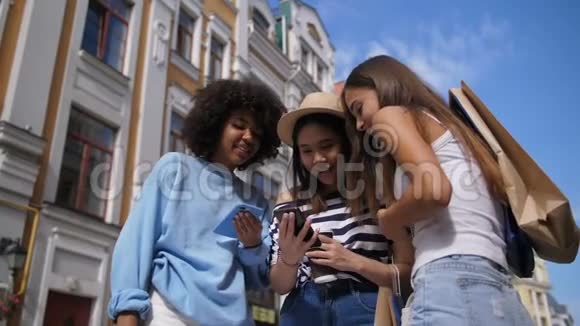 可爱的多种族女孩在户外分享智能手机视频的预览图