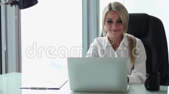 年轻英俊的女商人在她办公室的电脑上工作视频的预览图