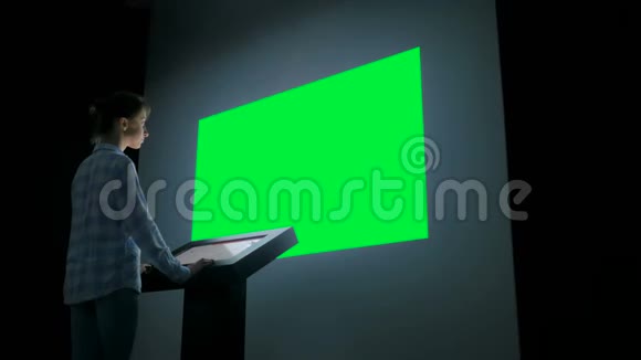 绿色屏幕色度关键概念女人看空的大墙显示器视频的预览图