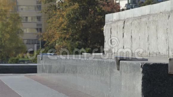 滑板手在街边的建筑纪念碑上玩50的把戏视频的预览图