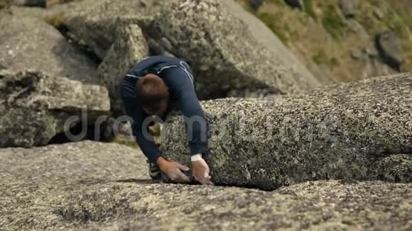 一个勇敢的人爬上岩石视频的预览图