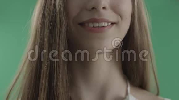 性感的女人咬着她的嘴唇紧贴着绿色的背景视频的预览图