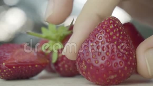 盘子里的成熟草莓草莓用手拿用刀切视频的预览图