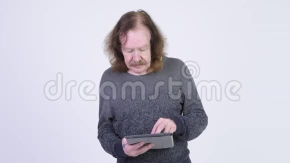 戴胡子的快乐老人使用数码平板电脑得到好消息视频的预览图